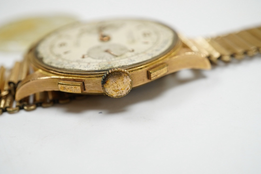 A gentleman's yellow metal Swiss chronograph manual wind wrist watch (lacking back cover), on a gold plated strap. Condition - poor.